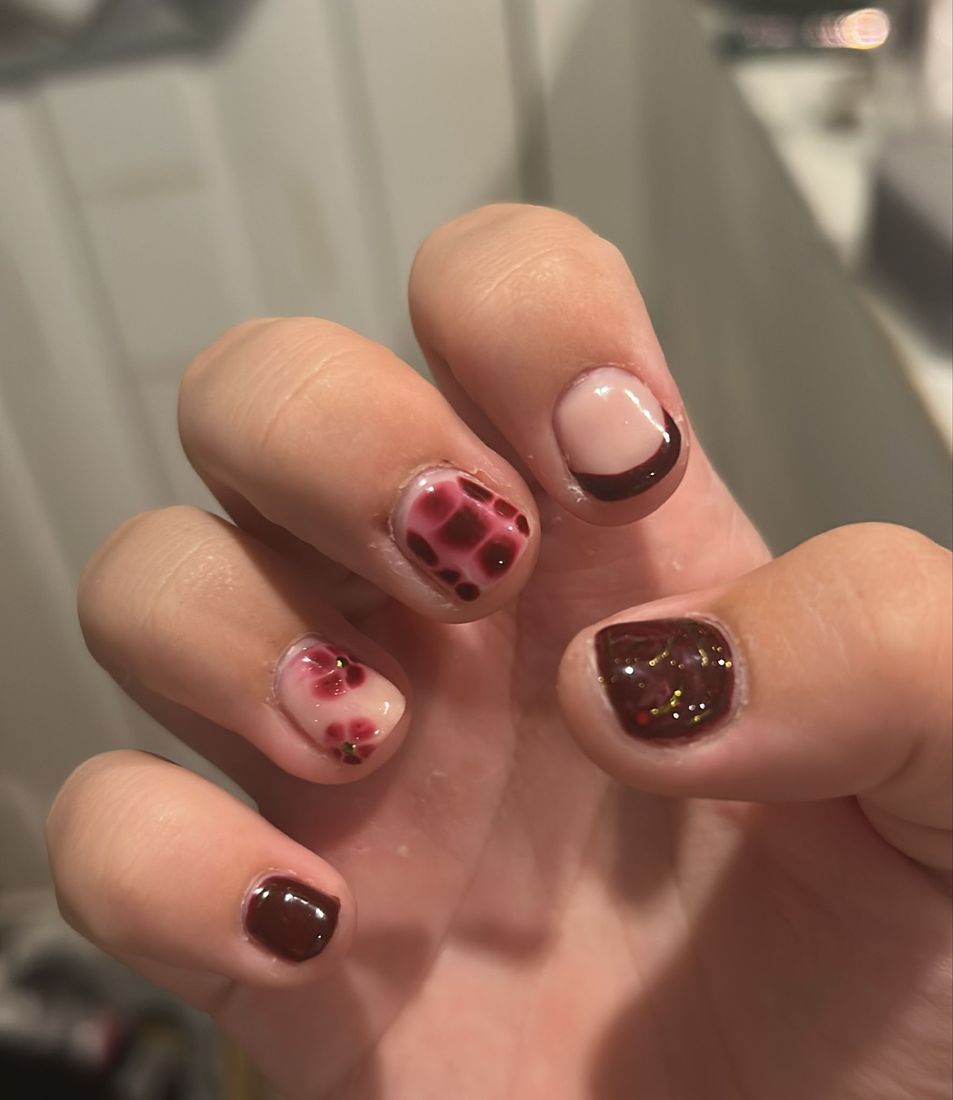 Short square nails in chocolate brown with a red check and heart design